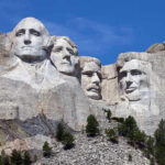 Mount Rushmore with four presidential faces carved in rock.
