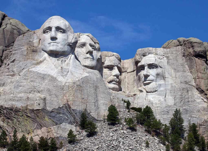 Mount Rushmore with four presidential faces carved in rock.