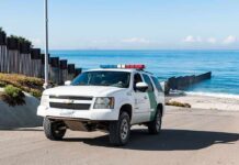 Border patrol SUV parked near beach fence