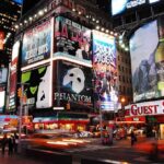 Vibrant night scene of Times Square filled with theater advertisements and neon lights