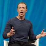 man speaking on stage with hands gesturing