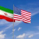 Iran and United States flags waving on flagpoles
