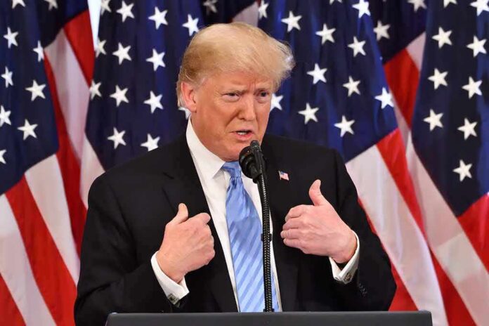 Donald Trump speaking at a podium with American flags behind him