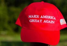 Red baseball cap with political slogan and small U.S. flag patch