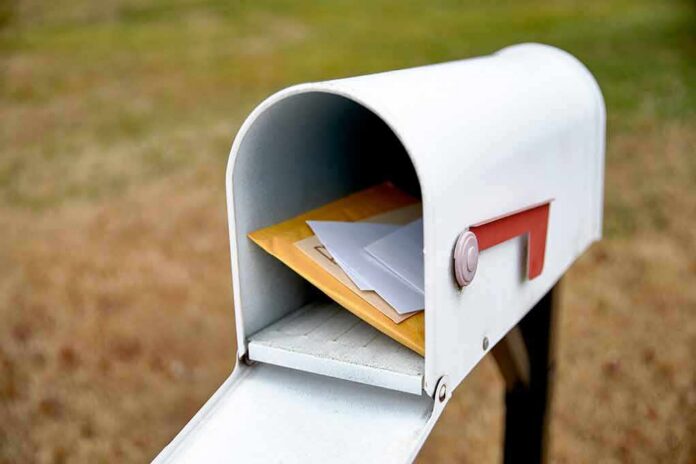 White mailbox with red flag holding envelopes and padded mailers