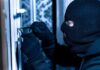 Masked person picking a door lock