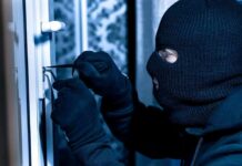 Masked person picking a door lock