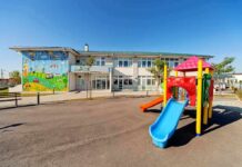 Playground with colorful slide in front of a school building