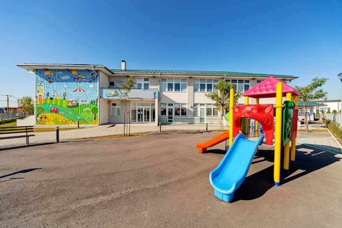 Playground with colorful slide in front of a school building