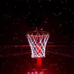 Basketball hoop glowing under red spotlight