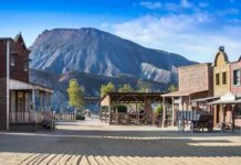 Old western town set against a mountain backdrop