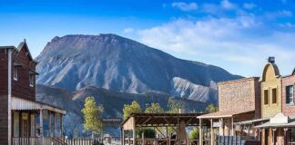 Old western town set against a mountain backdrop