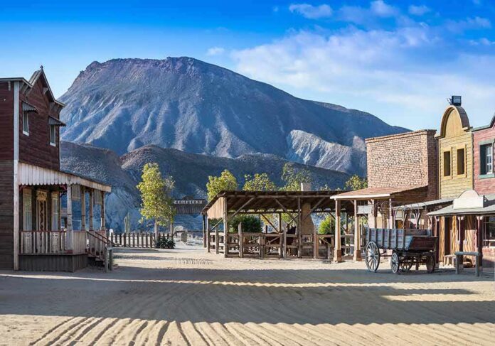 Old western town set against a mountain backdrop