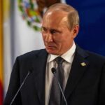 Vladimir Putin at a podium during a formal event