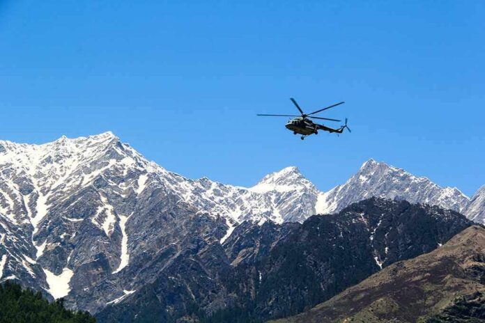 Helicopter flying over snow-capped mountain range