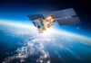 Satellite with solar panels orbiting above Earth