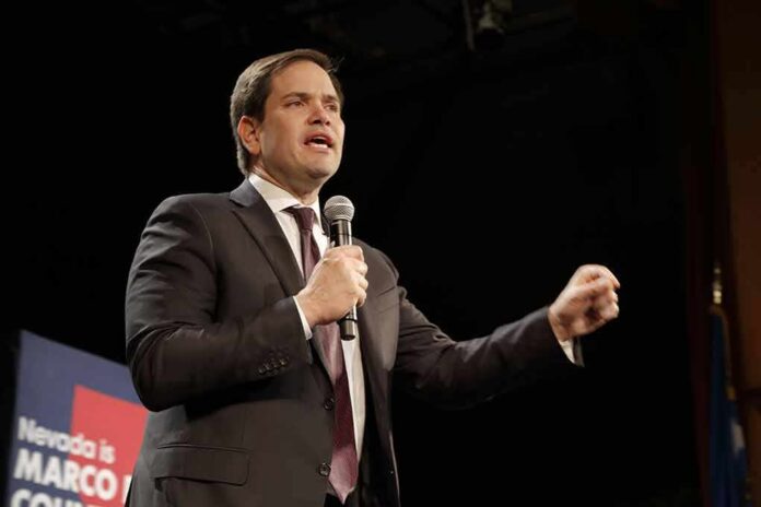 man in suit speaking into a microphone on stage