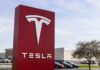 Tesla dealership sign in front of parking lot
