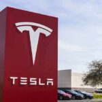Tesla dealership sign in front of parking lot