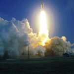 Rocket launching with bright exhaust and large smoke cloud