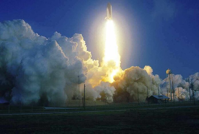 Rocket launching with bright exhaust and large smoke cloud