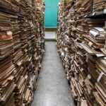 Aisle between shelves stacked with old paper files