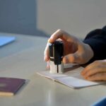 Hand stamping a passport on a desk