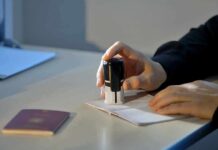 Hand stamping a passport on a desk