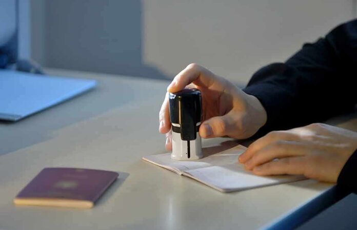 Hand stamping a passport on a desk