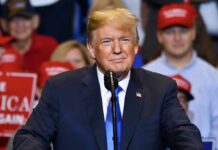 Donald Trump speaking at a rally podium
