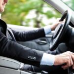 Driver in a suit operating a car