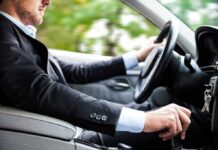 Driver in a suit operating a car