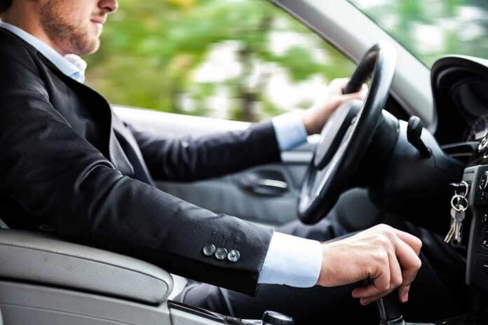 Driver in a suit operating a car