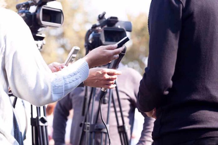 press interview with microphones and cameras outdoors