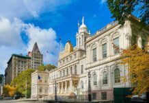 Tradition Killed – Jobs on the Line City hall building with classical architecture under a blue sky