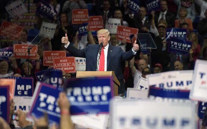 Donald Trump speaks at a rally, giving two thumbs up