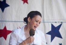 woman speaking into a microphone on a star-patterned backdrop