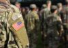 Soldier in camouflage with U.S. flag patch at formation