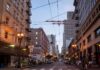 Urban street lined with mid-rise buildings at dusk
