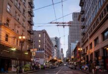 Urban street lined with mid-rise buildings at dusk