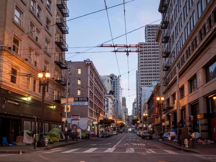Urban street lined with mid-rise buildings at dusk