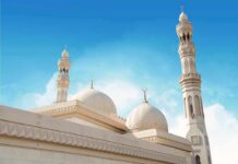 Mosque with domes and minarets against a clear blue sky