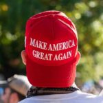 person wearing a red baseball cap at an outdoor gathering