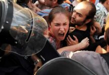 Protesters clash with riot police as woman shouts