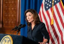 Sky-High Antisemitism, Explosive Hochul Quote Kathy Hochul speaking at a podium with microphones and a U.S. flag behind her