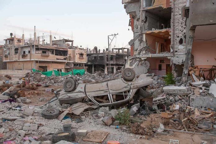 shutterstock_2091212767 Overturned car amid rubble and heavily damaged buildings