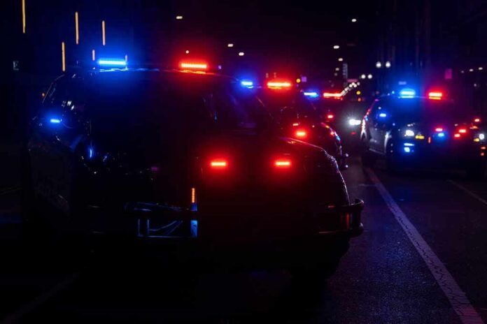 Police vehicles with flashing red and blue lights at night