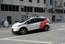 Autonomous test car with roof sensors on a city street
