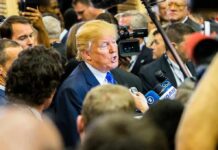 Donald Trump speaks to reporters in a crowded media scrum
