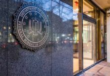 FBI emblem on a stone wall beside a glass entrance